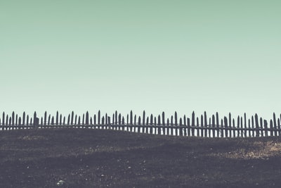 棕色沙滩上的棕色木栅栏